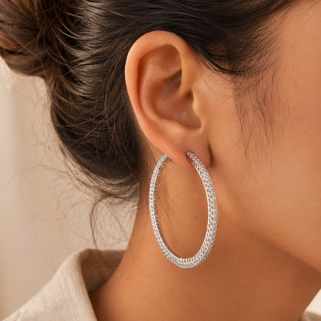 The YK Jewels large diamond hoop earrings, encrusted with sparkling stones, worn by a model.